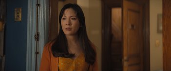 Movie still from “Lyle, Lyle, Crocodile” (2022), directed by Will Speck – A woman with long black hair wearing an orange top; Close Up shot, Over the shoulder angle