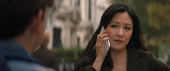 Movie still from “Lyle, Lyle, Crocodile” (2022), directed by Will Speck – A woman talking on a cell phone while standing on a sidewalk; Close Up shot, Over the shoulder angle