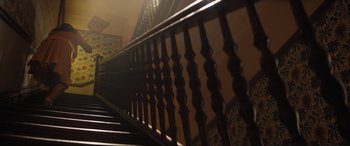 Movie still from “Lyle, Lyle, Crocodile” (2022), directed by Will Speck – A wooden railing on the side of a staircase; Extreme Wide shot, Low angle