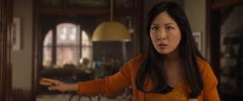 Movie still from “Lyle, Lyle, Crocodile” (2022), directed by Will Speck – A woman in an orange sweater holding her arm out; Close Up shot, Over the shoulder angle