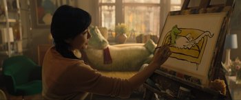 Movie still from “Lyle, Lyle, Crocodile” (2022), directed by Will Speck – A woman is painting a picture in a living room; Medium shot, Over the shoulder angle