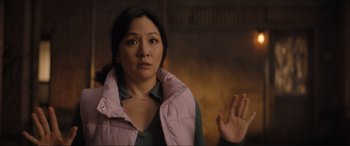 Movie still from “Lyle, Lyle, Crocodile” (2022), directed by Will Speck – A woman in a pink jacket holding her hand up to her face; Medium shot, Over the shoulder angle