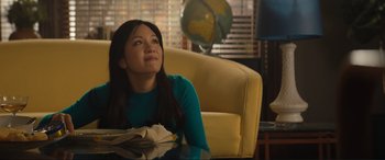 Movie still from “Lyle, Lyle, Crocodile” (2022), directed by Will Speck – A woman sitting at a table looking up at the sky; Medium shot, Low angle