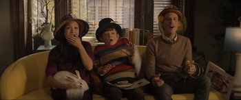 Movie still from “Lyle, Lyle, Crocodile” (2022), directed by Will Speck – A group of people sitting on top of a yellow couch; Medium shot, High angle