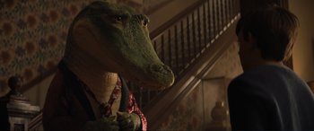 Movie still from “Lyle, Lyle, Crocodile” (2022), directed by Will Speck – An alligator wearing a suit and tie standing in front of a staircase; Medium shot, Low angle