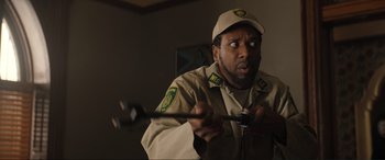 Movie still from “Lyle, Lyle, Crocodile” (2022), directed by Will Speck – A man holding a wrench in his hand while wearing a uniform; Close Up shot, Over the shoulder angle