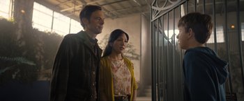 Movie still from “Lyle, Lyle, Crocodile” (2022), directed by Will Speck – A man and a woman standing next to each other in front of an iron gate; Medium shot, Low angle