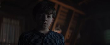 Movie still from “Lyle, Lyle, Crocodile” (2022), directed by Will Speck – A young boy is standing in a dark room; Close Up shot, Low angle