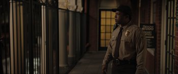 Movie still from “Lyle, Lyle, Crocodile” (2022), directed by Will Speck – A police officer standing on the side of the street; Medium shot, Low angle