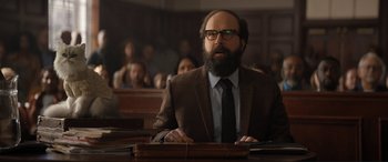 Movie still from “Lyle, Lyle, Crocodile” (2022), directed by Will Speck – A man with a beard and glasses sitting in a courtroom; Close Up shot, Low angle