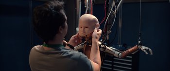 Movie still from “M3GAN” (2022), directed by Gerard Johnstone – A man is adjusting the wires on a mannequin head; Close Up shot, High angle