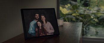 Movie still from “M3GAN” (2022), directed by Gerard Johnstone – A picture frame with a picture of a young family on it; Extreme Close Up shot, High angle