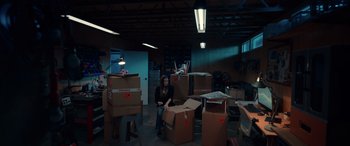 Movie still from “M3GAN” (2022), directed by Gerard Johnstone – A woman sitting on the floor in a room full of boxes; Wide shot, High angle