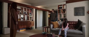 Movie still from “M3GAN” (2022), directed by Gerard Johnstone – Two people are sitting in a living room; Wide shot, Low angle