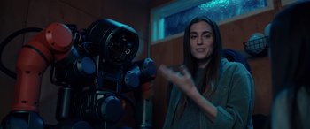 Movie still from “M3GAN” (2022), directed by Gerard Johnstone – A woman standing in front of a video camera; Medium shot, Over the shoulder angle