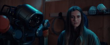 Movie still from “M3GAN” (2022), directed by Gerard Johnstone – A woman standing in front of a large telescope; Close Up shot, Low angle