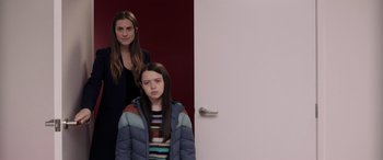 Movie still from “M3GAN” (2022), directed by Gerard Johnstone – A woman standing next to a young girl in front of a door; Medium shot, Low angle