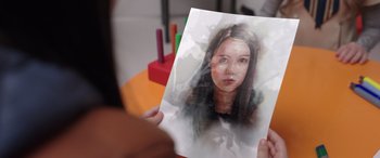 Movie still from “M3GAN” (2022), directed by Gerard Johnstone – A person holding up a picture of a woman; Extreme Close Up shot, Over the shoulder angle