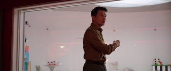 Movie still from “M3GAN” (2022), directed by Gerard Johnstone – A man standing in a room holding a remote control; Medium shot, Low angle