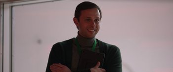 Movie still from “M3GAN” (2022), directed by Gerard Johnstone – A man in a green sweater holding a tablet computer; Close Up shot, Low angle