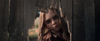 Movie still from “M3GAN” (2022), directed by Gerard Johnstone – A young girl with long blonde hair wearing a brown jacket; Close Up shot, Low angle