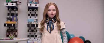 Movie still from “M3GAN” (2022), directed by Gerard Johnstone – A girl with long brown hair wearing a dress and a striped tie; Close Up shot, Low angle