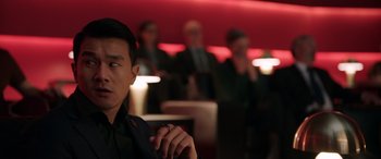 Movie still from “M3GAN” (2022), directed by Gerard Johnstone – A man smoking a cigarette in front of a group of people; Close Up shot, Over the shoulder angle