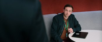 Movie still from “M3GAN” (2022), directed by Gerard Johnstone – A man sitting at a table with a plate in front of him; Medium shot, Over the shoulder angle