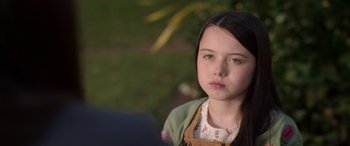 Movie still from “M3GAN” (2022), directed by Gerard Johnstone – A young girl is standing in front of a tree; Close Up shot, Over the shoulder angle