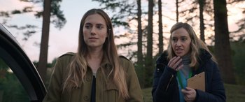 Movie still from “M3GAN” (2022), directed by Gerard Johnstone – Two women standing next to each other near a forest; Close Up shot, Over the shoulder angle