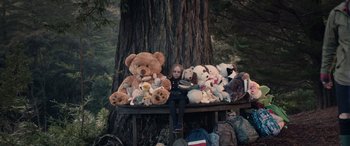 Movie still from “M3GAN” (2022), directed by Gerard Johnstone – A little girl sitting on top of a pile of stuffed animals; Wide shot, Low angle