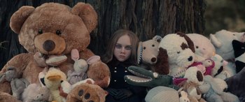 Movie still from “M3GAN” (2022), directed by Gerard Johnstone – A girl sitting in a pile of stuffed animals; Medium shot, High angle