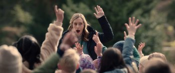 Movie still from “M3GAN” (2022), directed by Gerard Johnstone – A crowd of people with their hands in the air; Medium shot, Over the shoulder angle