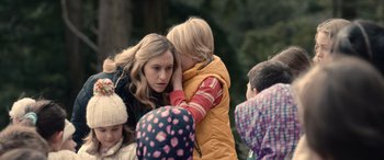Movie still from “M3GAN” (2022), directed by Gerard Johnstone – A group of people that are standing up together; Close Up shot, Over the shoulder angle