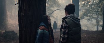 Movie still from “M3GAN” (2022), directed by Gerard Johnstone – Two people standing next to each other near a tree; Medium shot, Over the shoulder angle