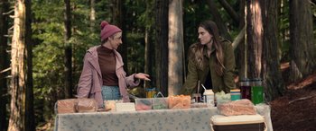 Movie still from “M3GAN” (2022), directed by Gerard Johnstone – Two women standing at a table in a park; Medium shot, Over the shoulder angle