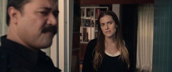 Movie still from “M3GAN” (2022), directed by Gerard Johnstone – A woman standing in front of a door looking at the camera; Close Up shot, Over the shoulder angle