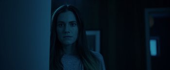 Movie still from “M3GAN” (2022), directed by Gerard Johnstone – A woman with long brown hair stares into the camera; Close Up shot, Low angle