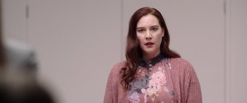 Movie still from “M3GAN” (2022), directed by Gerard Johnstone – A woman with red hair wearing a pink floral shirt; Close Up shot, Low angle
