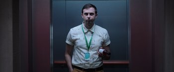 Movie still from “M3GAN” (2022), directed by Gerard Johnstone – A man in a white shirt holding a bottle of wine; Medium shot, Low angle