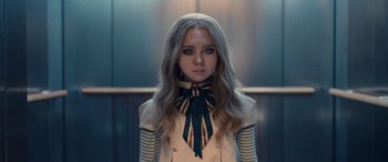 Movie still from “M3GAN” (2022), directed by Gerard Johnstone – A woman with long hair wearing a jacket and a neck tie; Close Up shot, Low angle