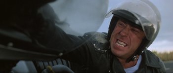 Movie still from “Mad Max” (1979), directed by George Miller – A person with a helmet on; Close Up shot, Low angle