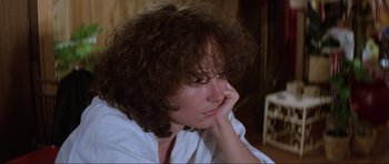 Movie still from “Mad Max” (1979), directed by George Miller – A person sitting with her head resting on her hand; Close Up shot, High angle