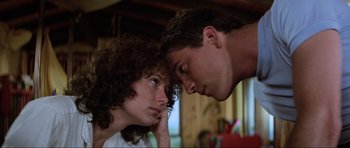 Movie still from “Mad Max” (1979), directed by George Miller – A man and a woman looking at one another; Close Up shot, Low angle