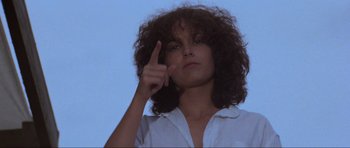 Movie still from “Mad Max” (1979), directed by George Miller – A woman with curly hair is pointing to the sky; Close Up shot, Low angle