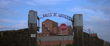 Movie still from “Mad Max” (1979), directed by George Miller – A stop sign in front of some buildings; Extreme Wide shot, Low angle