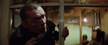 Movie still from “Mad Max” (1979), directed by George Miller – A man in a suit looking out of a window; Close Up shot, Low angle