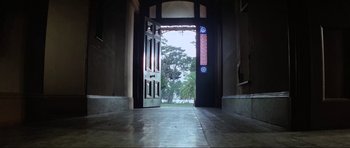Movie still from “Mad Max” (1979), directed by George Miller – An open door leading to a tropical garden; Wide shot, Low angle