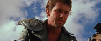Movie still from “The Road Warrior” (1981), directed by George Miller – A person wearing a leather jacket; Close Up shot, Low angle