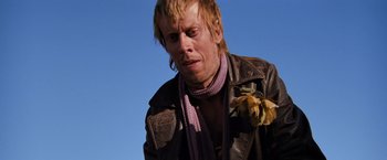 Movie still from “The Road Warrior” (1981), directed by George Miller – A person wearing a leather jacket; Close Up shot, Low angle